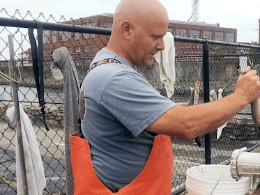 Capt. Tom Logan preparing some chum for a shark trip.